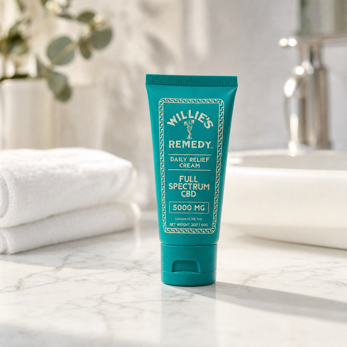 Willie's Remedy Daily Relief Cream on a bathroom counter next to folded towels
