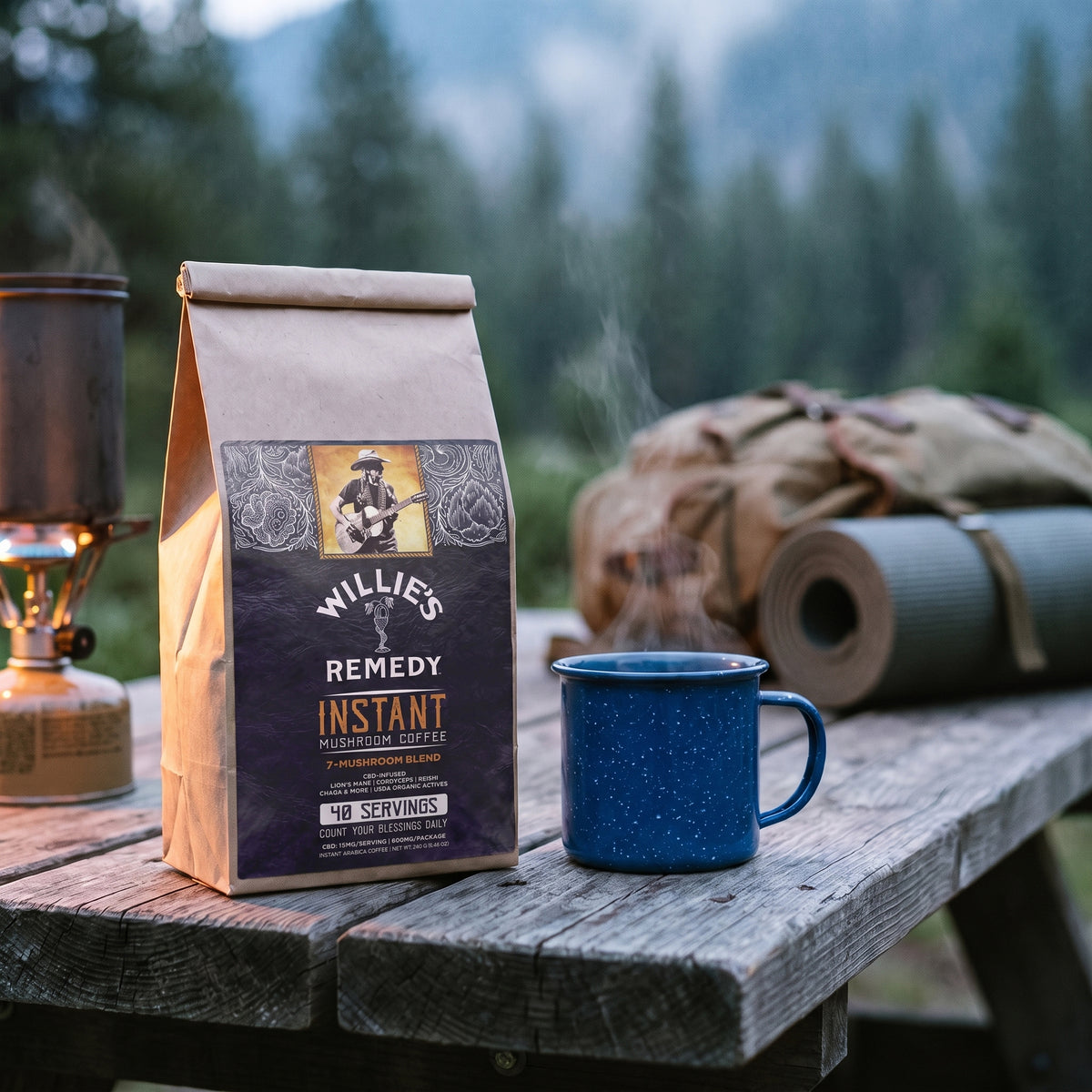 Willie's CBD Instant Mushroom Coffee on a camp table with an enamel mug