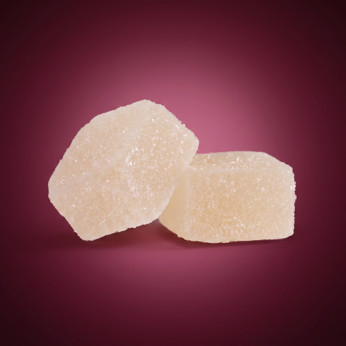 Close-up of two Sleep CBD gummies on a maroon background