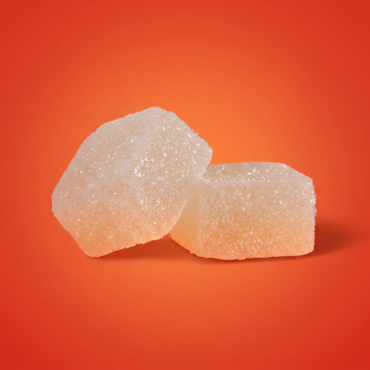 Close-up of two Wake CBD gummies on an orange background